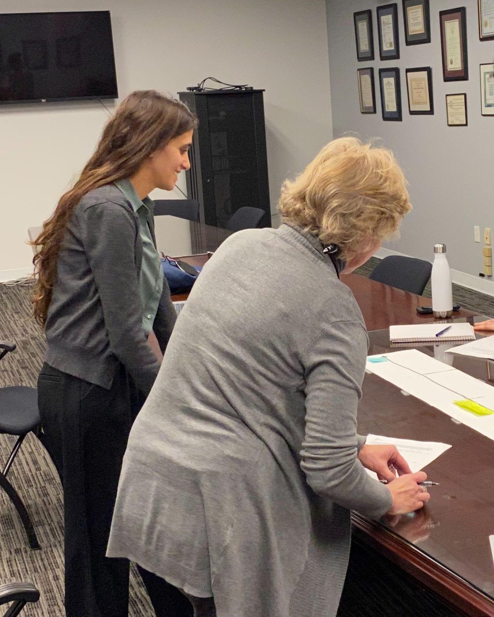 Two researchers reviewing materials together during a fieldwork interview with a victim advocate.